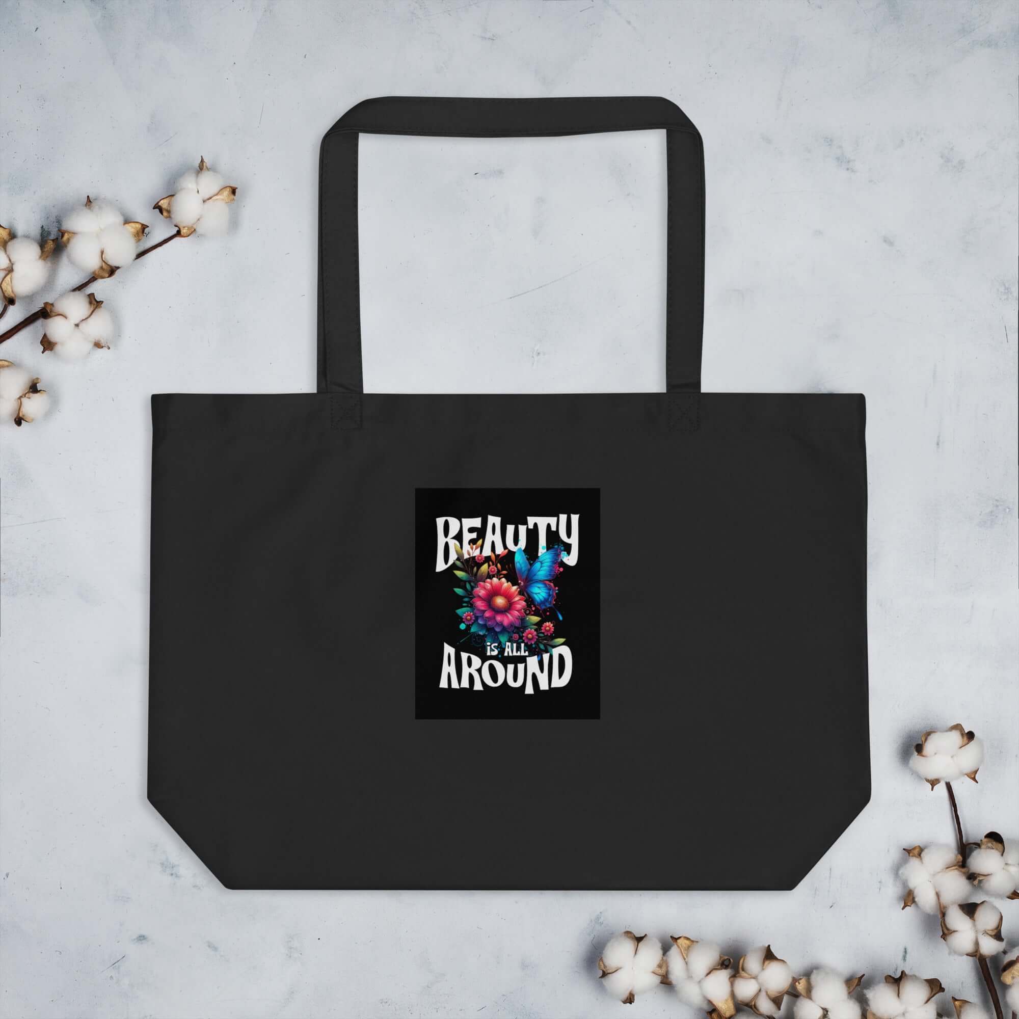 Black organic cotton tote bag with top handles and front graphic patch