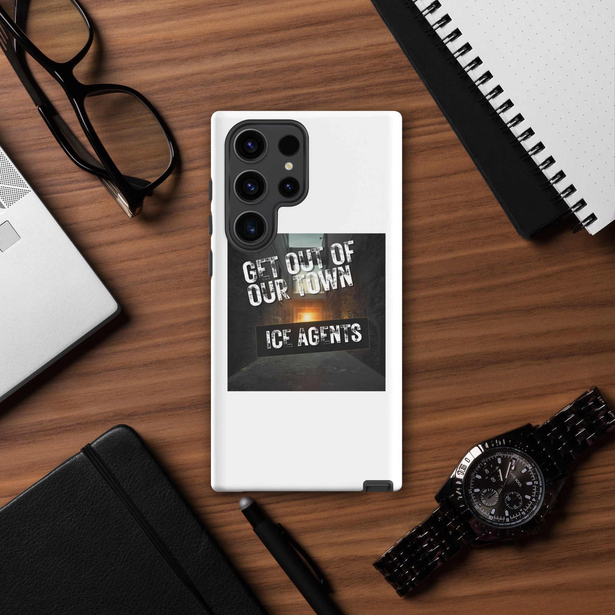 White phone case with black camera module and “GET OUT OF OUR TOWN” street-style design