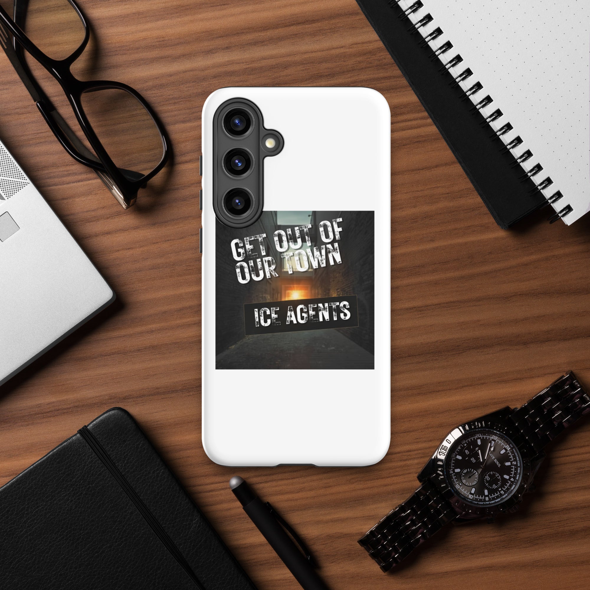 White phone case with black camera guard and “GET OUT OF OUR TOWN” typography artwork