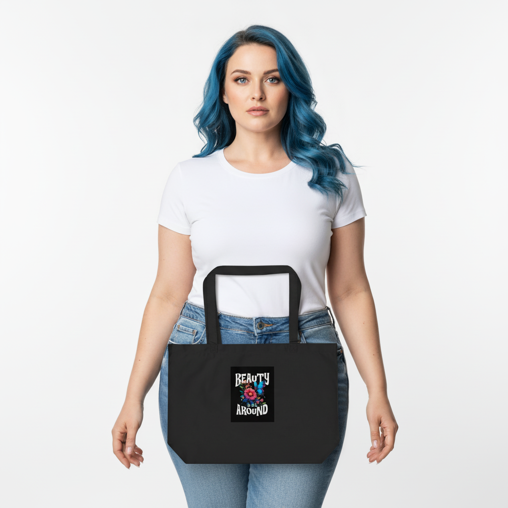 Organic cotton tote bag held by model, black with front graphic visible