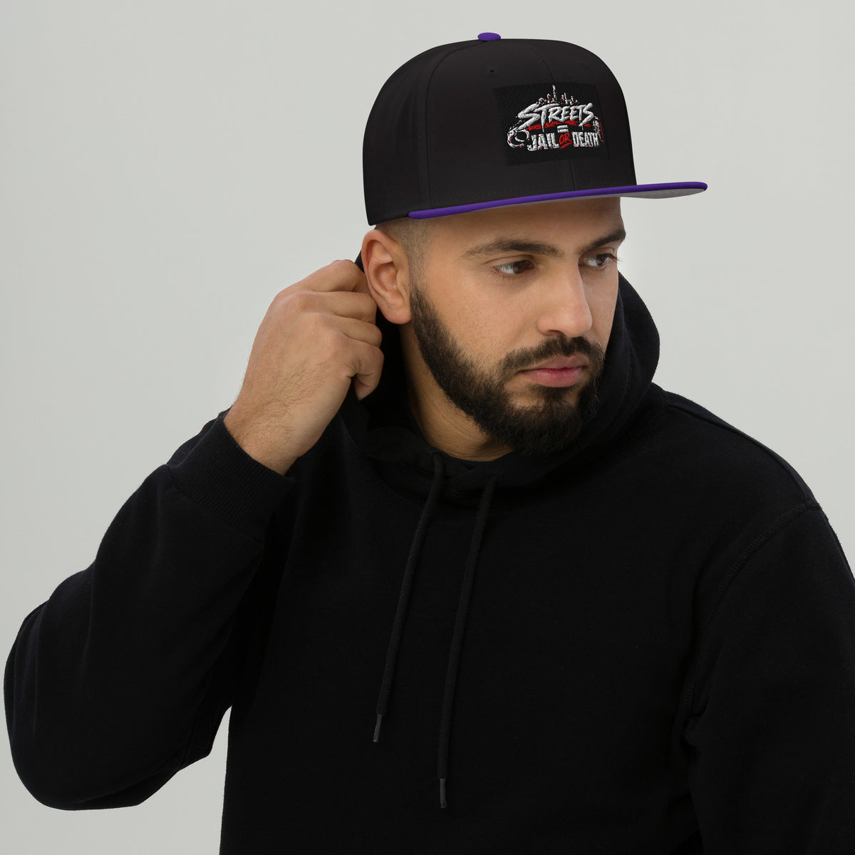 Black snapback hat with purple underbrim and embroidered front logo