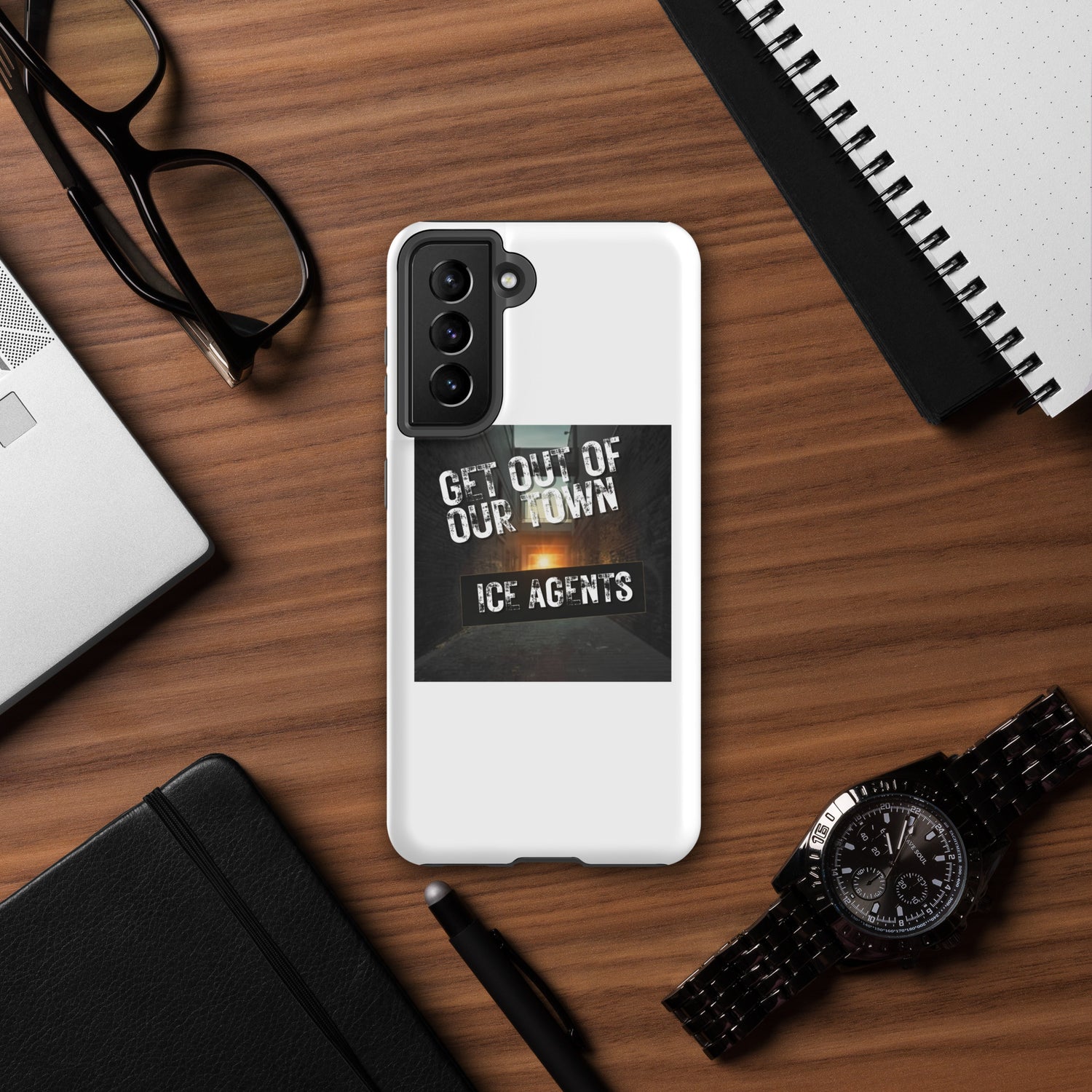 White phone case with black camera guard and “GET OUT OF OUR TOWN” graphic