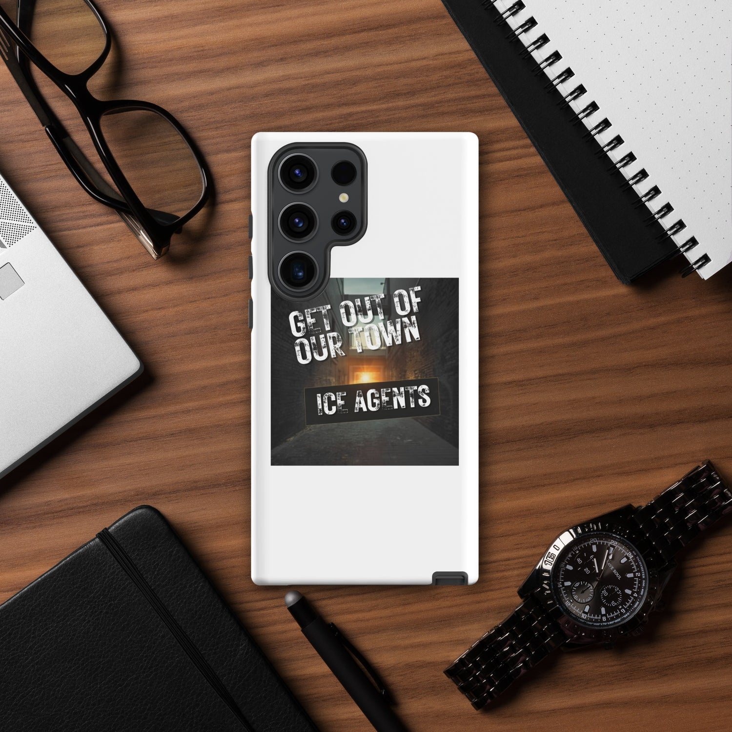 White phone case with black camera module and “GET OUT OF OUR TOWN” street-style design