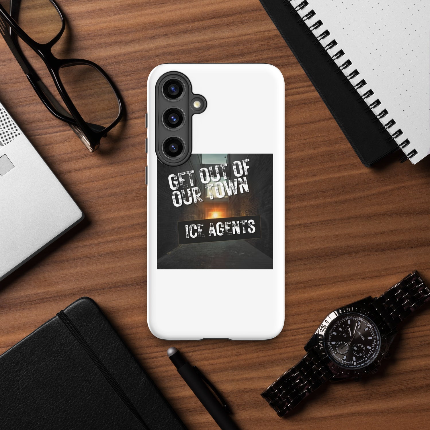White phone case with black camera guard and “GET OUT OF OUR TOWN” typography artwork