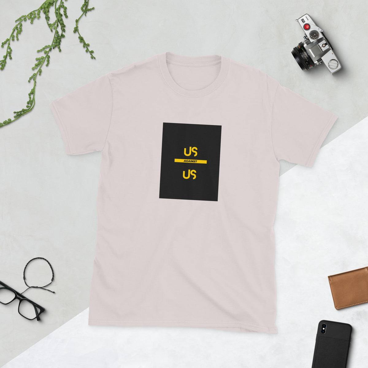 Blush pink graphic tee with black square logo and yellow accents, front view