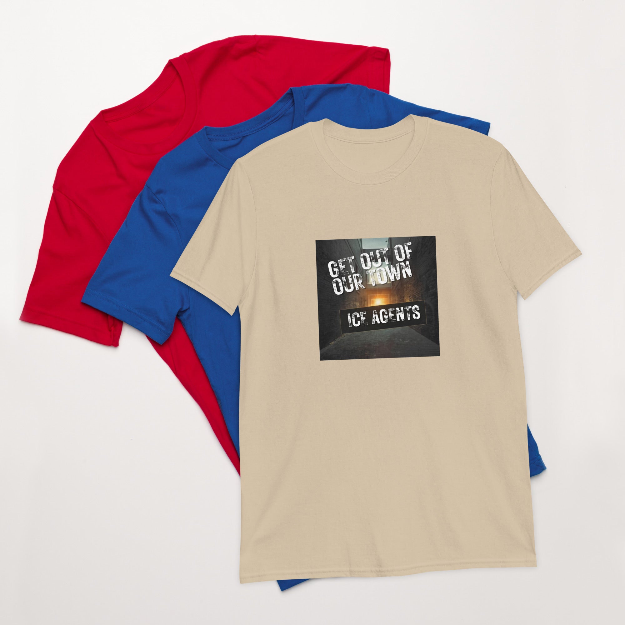 Natural/beige unisex T-shirt with square “Get out of our town” graphic; blue and red behind