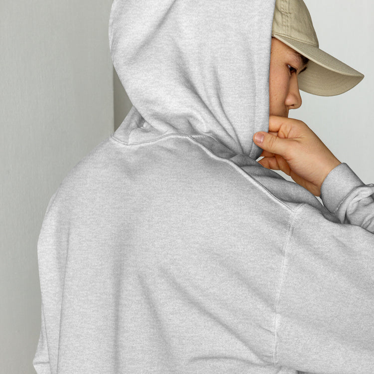 Heather gray unisex hoodie with drawstring hood, hand holding fabric near shoulder.