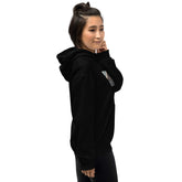 Black unisex hoodie with hood and chest graphic print, side view with one hand up.