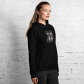 Black unisex pullover hoodie with hood and front pocket, chest graphic panel visible