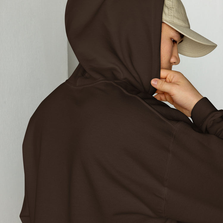 Brown unisex hoodie close-up with drawstring hood and front pouch, hand holding collar