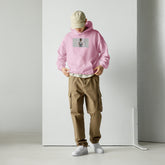 Unisex hoodie in light pink, front graphic and kangaroo pocket, adjustable hood.