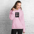 Light pink unisex hoodie with front logo patch, kangaroo pocket, and drawstring hood