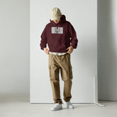Maroon unisex pullover hoodie with front pouch and chest graphic print, hood up