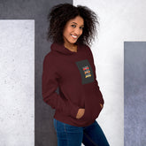 Unisex maroon pullover hoodie with hood, kangaroo pocket, and front graphic patch (front view)